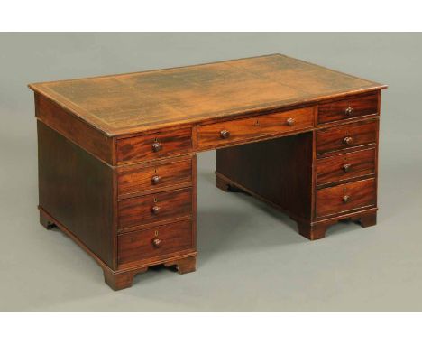A Victorian mahogany partners desk, with gilt tooled writing surface and fitted with three frieze drawers to either side and 