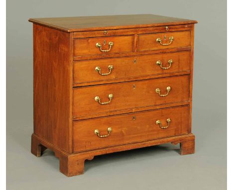 A George III mahogany chest of drawers, with moulded edge above a slide and fitted with two short and three long graduated dr