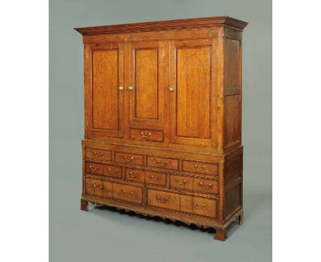 A good George III "Bewcastle" type inlaid oak press cupboard, in two stages, the upper stage with moulded cornice and plain f