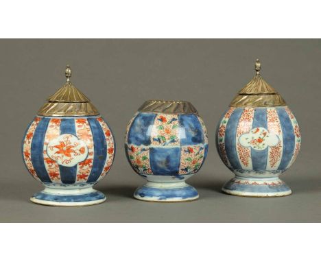 A garniture of three lidded vessels, with plated mounts, Imari colours.  Height of pair 5.5 ins. CONDITION REPORT: The odd va