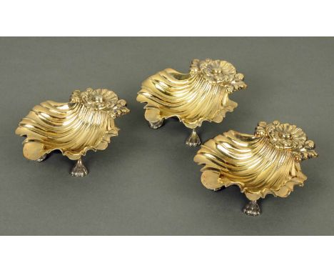A set of three George IV silver gilt salts, Sheffield 1929, maker R. Gainsford, each in the form of a shell raised on paw fee