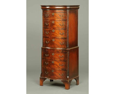 An early 20th century mahogany serpentine fronted chest on chest, with canted blind fretwork angles and raised on bracket fee