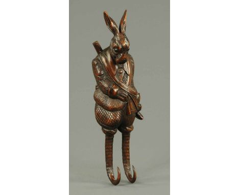 A carved wooden hare whip/hat rack.  Height 19 ins. 