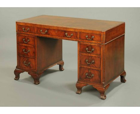 A mahogany pedestal desk, with gilt tooled leather writing surface, moulded edge and three frieze drawers and with three furt