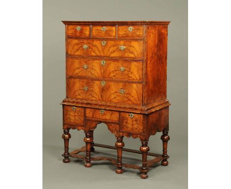 A William & Mary walnut veneered chest on stand, with moulded cornice above three short and three long drawers, the base fitt