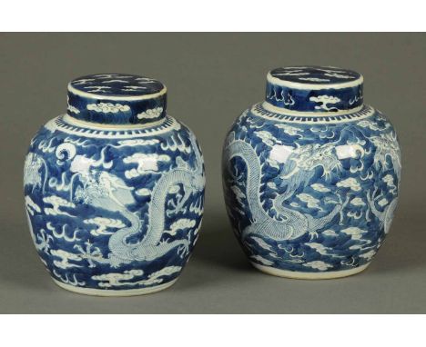 A pair of 19th century Chinese blue and white ginger jars, each decorated with dragons, lidded and bearing character marks to