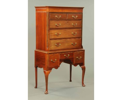 A mahogany chest on stand, first half 20th century, fitted with a series of drawers flanked by canted angles and raised on ca