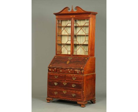 A George III mahogany bureau bookcase, with swans neck pediment above a pair of glazed doors enclosing shelves, the matched b