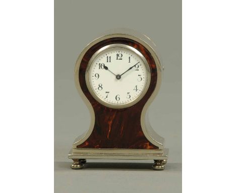 An Edwardian silver plated and tortoiseshell alarm clock, balloon shaped, with Arabic numerals and wind and alarm mechanisms 