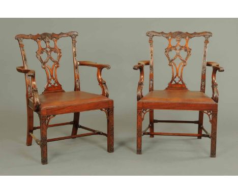 A pair of Edwardian Chippendale style armchairs, with pierced and carved splat backs, outswept arms with scroll supports, dro