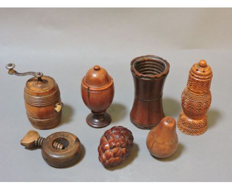 A collection of treen items, to include a pepper grinder in the form of a barrel, a fruitwood pear, and a carved treen coquil