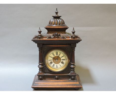 A German walnut mantel clock, striking on a bell, 42cm high