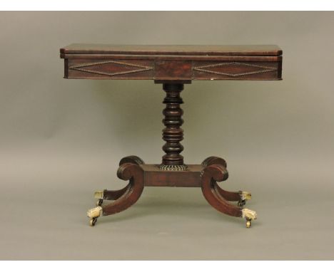 A 19th century mahogany card table, with turned column and four scrolling legs, 91.5cm wide