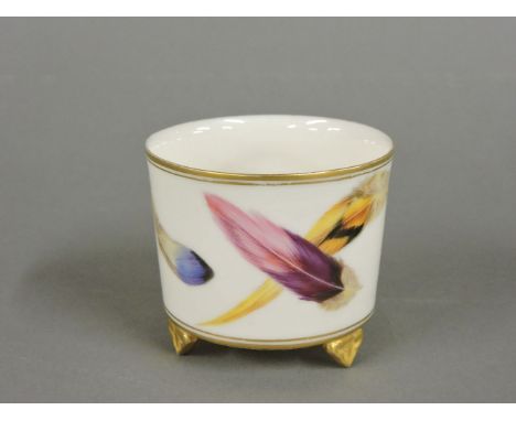 A Royal Worcester vase, painted with feathers, on three gilt feet, stamped green, printed mark for 1877 and 'D', 6cm high