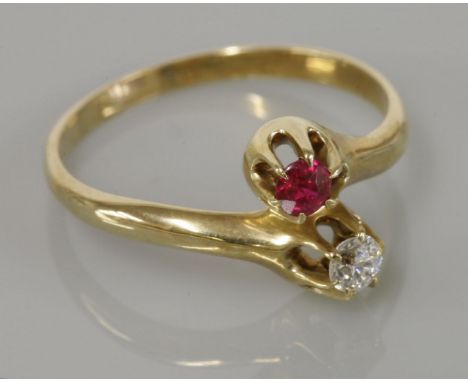 An American two stone diamond and synthetic ruby crossover ring, circa 1910, marked 14k, maker's mark unidentified