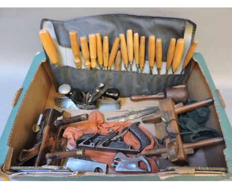 A box of woodworking tools, including a Stanley No.13 compass plane, a roll of carving chisels, two plough planes, a Stanley 