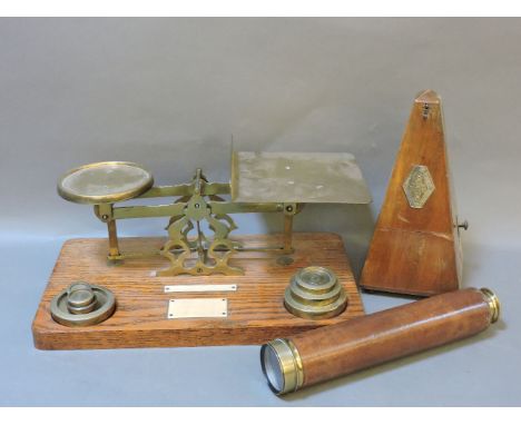A set of brass postal scales, a Paquet metronome, and a three-draw brass and leather telescope, engraved 'WM Oldfied, Skipton