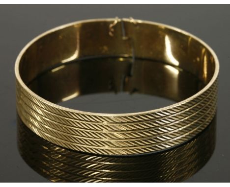 A 9ct gold diamond cut bangle, 'Nymph' patent no: 1052231, 23.82g