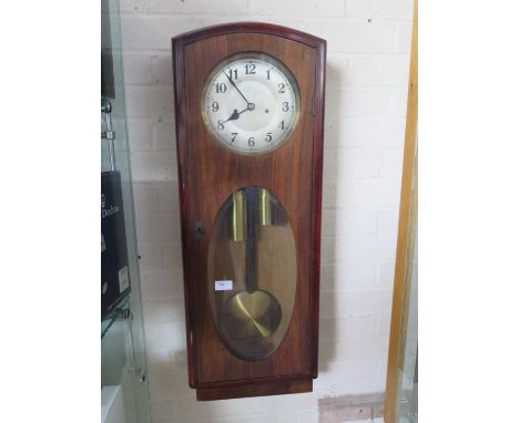 A mahogany case eight day weight driven wall clock, strikes hours and half hours on rod, oval glass door to front - 84cm tall