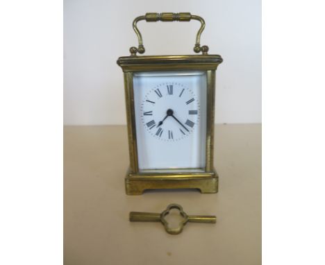 A brass carriage clock - 12cm tall, generally good condition with key 