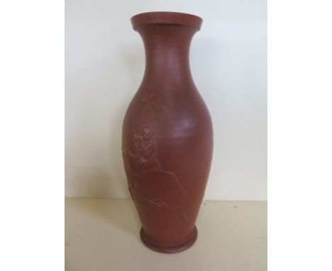 An oriental red ware vase with a boy playing a flute on an oxens back 34cm tall, good condition minor marks 