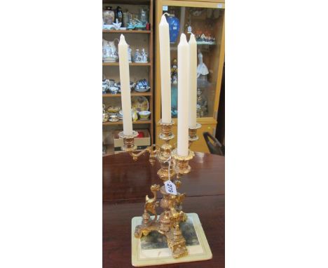 A gilt four branch candelabra with winged griffin supports