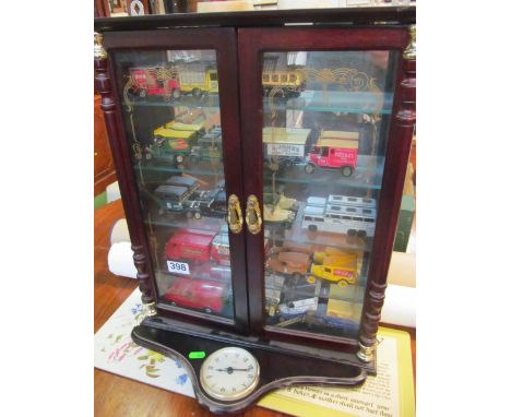 Some model cars in cabinet and two Hummel figures (one a/f)