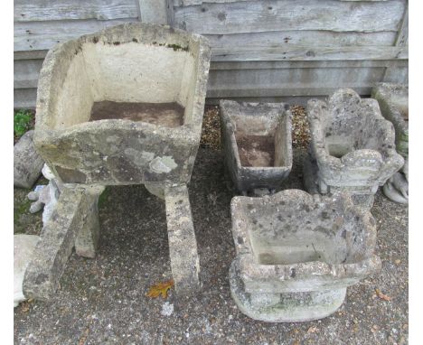 A concrete wheelbarrow planter, smaller one and two carriages