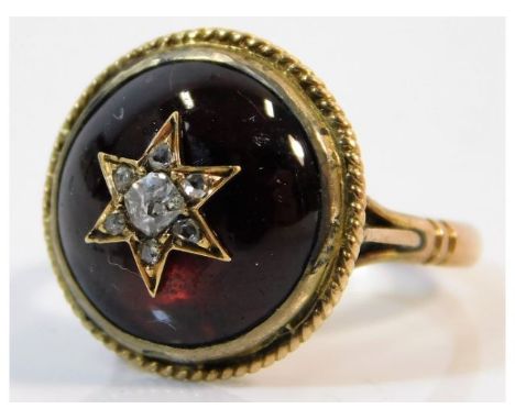 A 19thC. yellow metal ring, shank electronically tests as 10ct gold, set with cabouchon cut garnet &amp; old cut diamonds, si