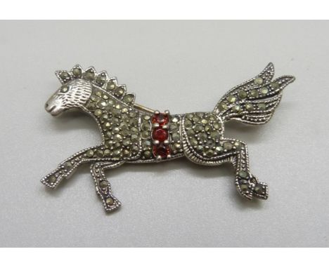 A silver, marcasite and red stone horse brooch 