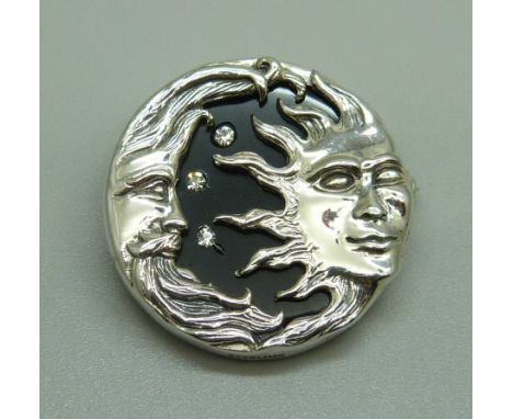 A silver sun and moon brooch 