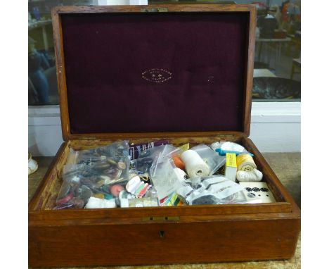 An oak rectangular cutlery box with lift out shelf containing sewing implements, a bag of buttons, cotton reels and other hab