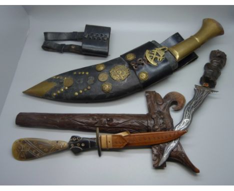 A Nepalese kukri with engraved blade, decorative leather scabbard with regimental badge, buttons and coins, an Indonesian kri