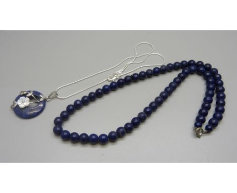 A lapis lazuli and mother of pearl pendant on a silver chain and a lapis lazuli bead necklace 
