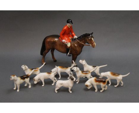 A Beswick fox hunting group, with huntsman on brown horse, 2 first version hounds, 6 second version hounds and a terrier.