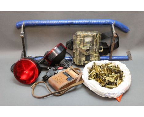 A quantity of brass 270 cases, two lamps, squeaker box, trail camera and a homemade vehicle shooting rest.
