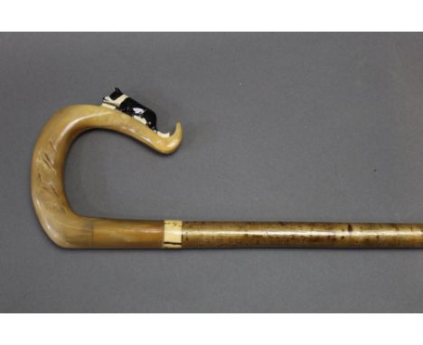 A hazel shafted walking stick, with antler and horn handle, the horn section with carved border collie decoration.  Length 12