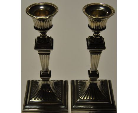 A pair of George V silver dwarf candlesticks of Neoclassical design on beaded square base, William Hutton & Son, Sheffield 19