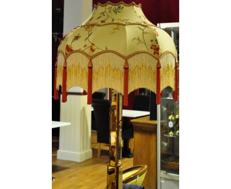 An Art Deco amber glass standard lamp with associated embroidered shade, the graduated column on stepped square base