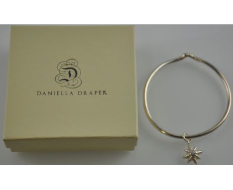A designer Daniella Draper silver bangle hung with a star charm