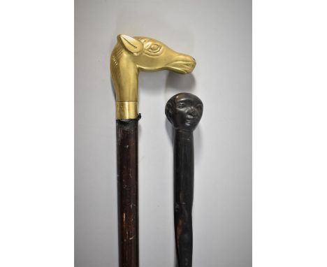 An Ebonised African Wooden Staff with Carved Mask Pommel Together with a Brass Mounted Waling Stick with Horses Head Handle 