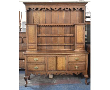 A George III Style Oak Dresser Having Centre Cupboard Flanked by Two Short Crossbanded Drawers Having Pierced Brass Drop Hand