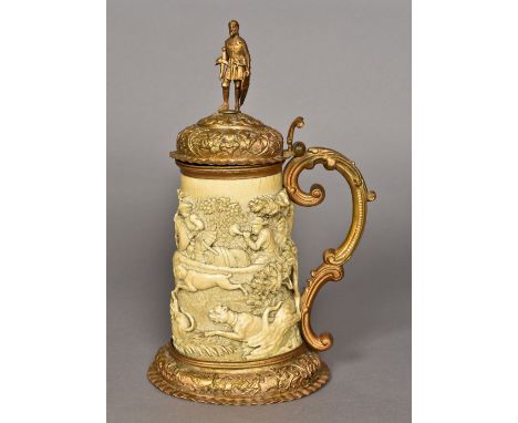 A 19th century carved ivory tankardCarved in the round with a boar hunting scene, surmounted with gilt metal mounts, the top 