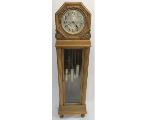 A CONTINENTAL OAK LONGCASE CLOCK the silvered dial within a carved foliate hood above a glazed door, flanked by pillars, 204c