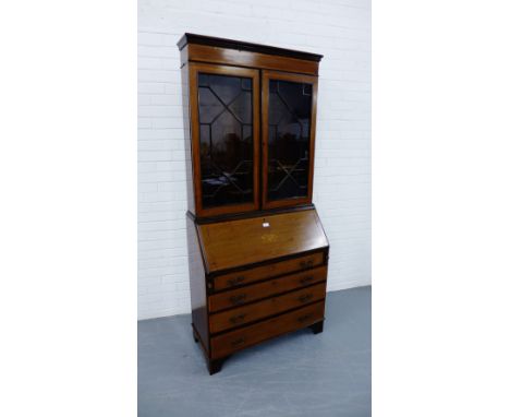 An Edwardian inlaid mahogany bureau bookcase having a moulded cornice over astragal glazed panel doors, enclosing a shelved i