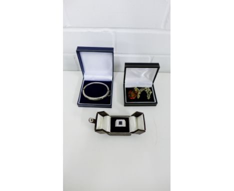 Gents silver and paste set ring, amber pendant on gilt metal chain and a white metal stiff hinged bangle (3)