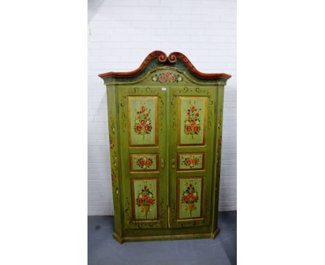 A 19th century continental painted pine linen press having a carved swan neck pediment to top over two panel doors enclosing 