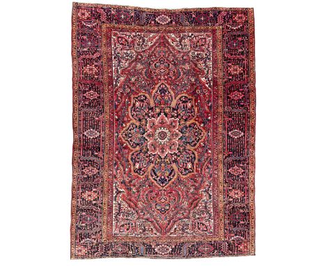 Antique Persian coral ground carpet, the large central floral pole medallion with extending foliate designs, the thick guarde