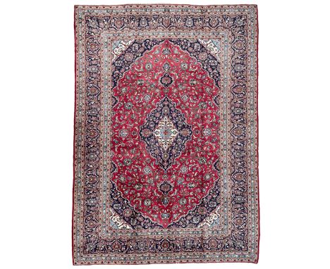 Central Persian Kashan crimson ground carpet, central  floral pole medallion with matching spandrels within a field of scroll