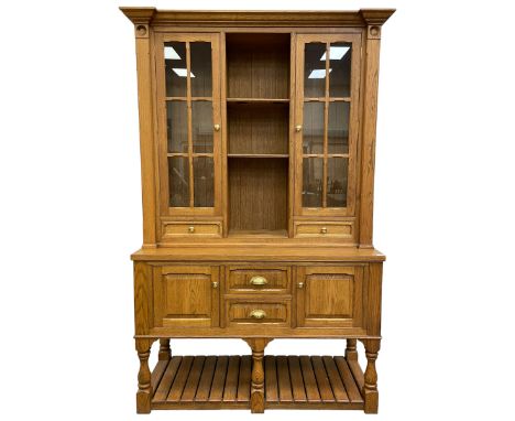 Light oak dresser, projecting cornice over display cabinets, shelves and drawers, the dresser base fitted with panelled cupbo